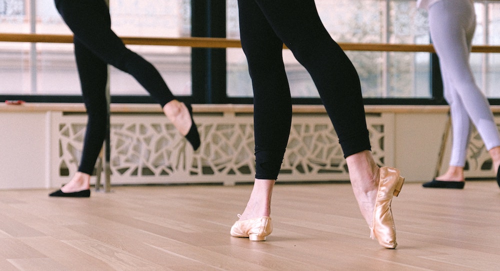 Dancers on a hardwood dance floor.