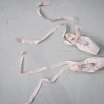 light pink pointe shoes on floor