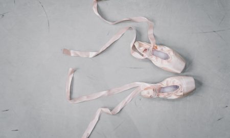 light pink pointe shoes on floor