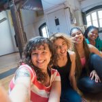 young women taking a group selfie at a dance studio