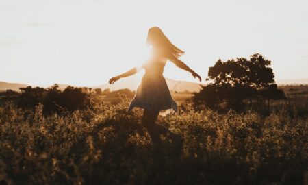 woman turning around on green fields