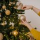 close up shot of a person putting christmas balls on a christmas tree