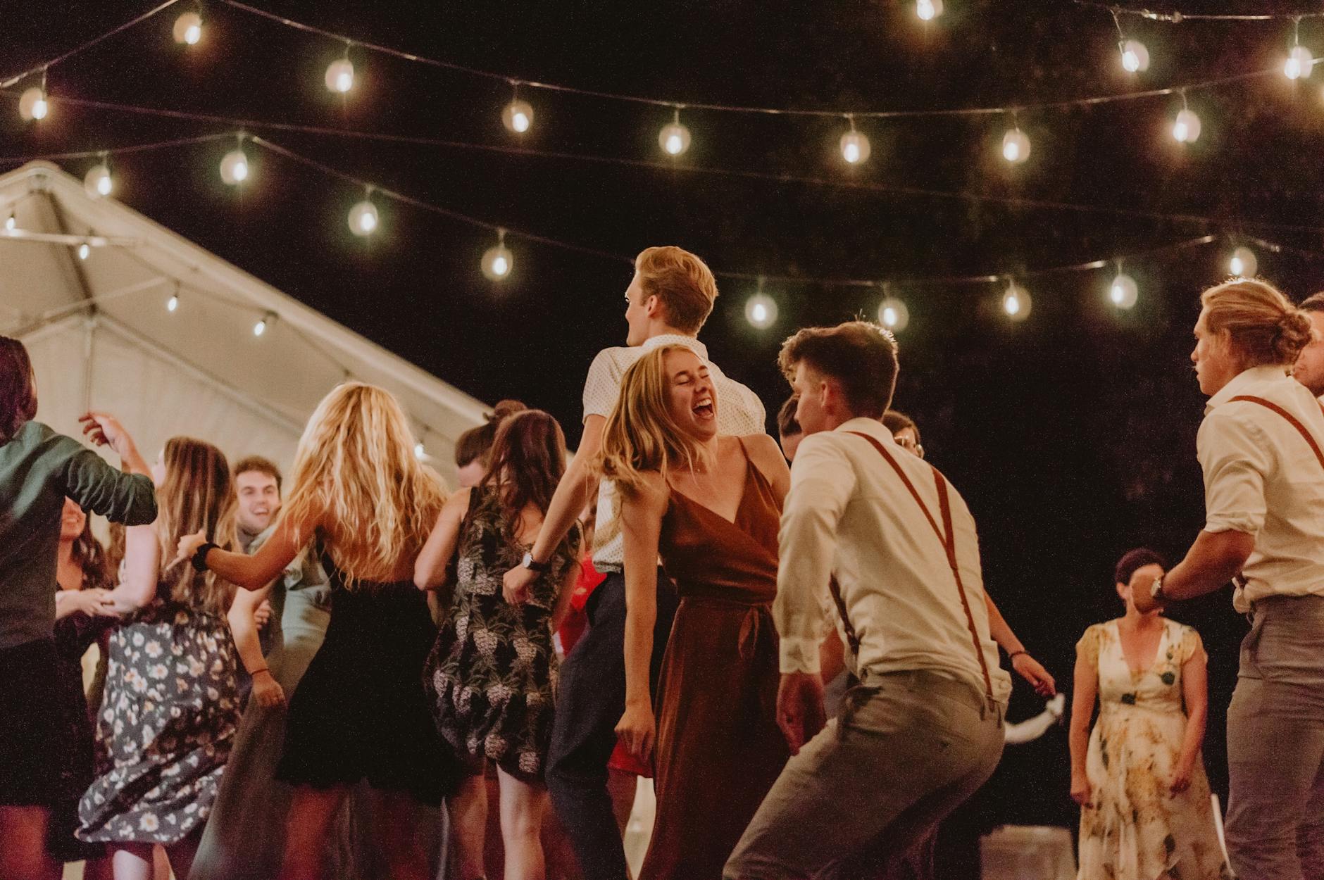 joyful outdoor night party with string lights